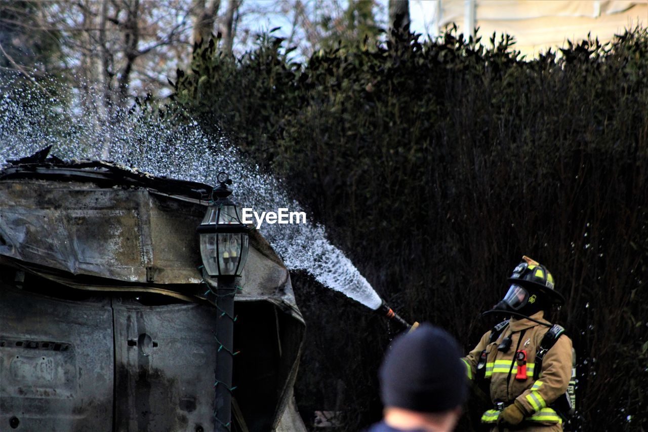 Firefighter spraying water on built structure