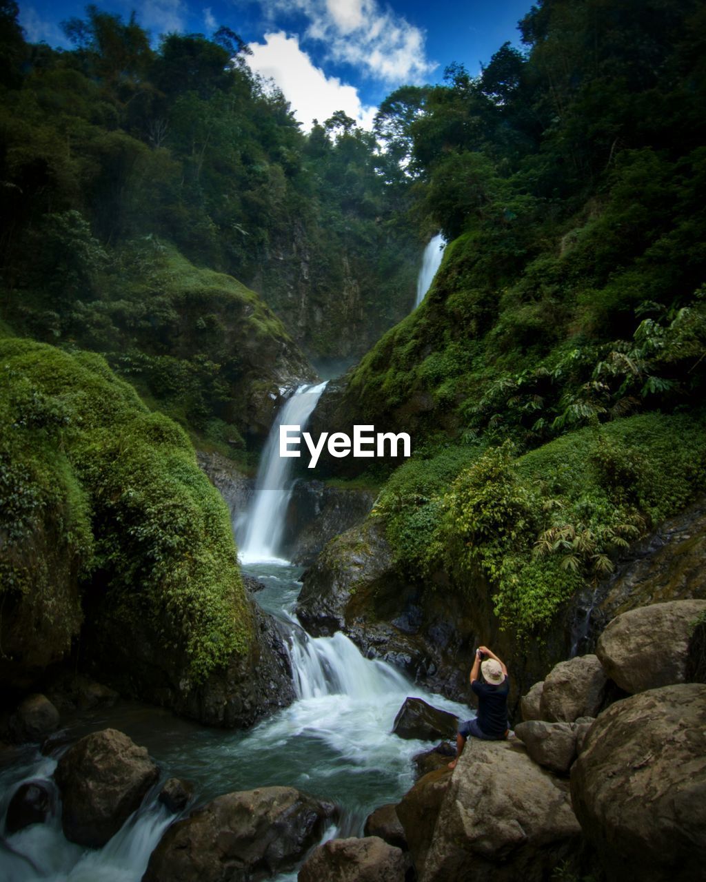 Man sitting at waterfall