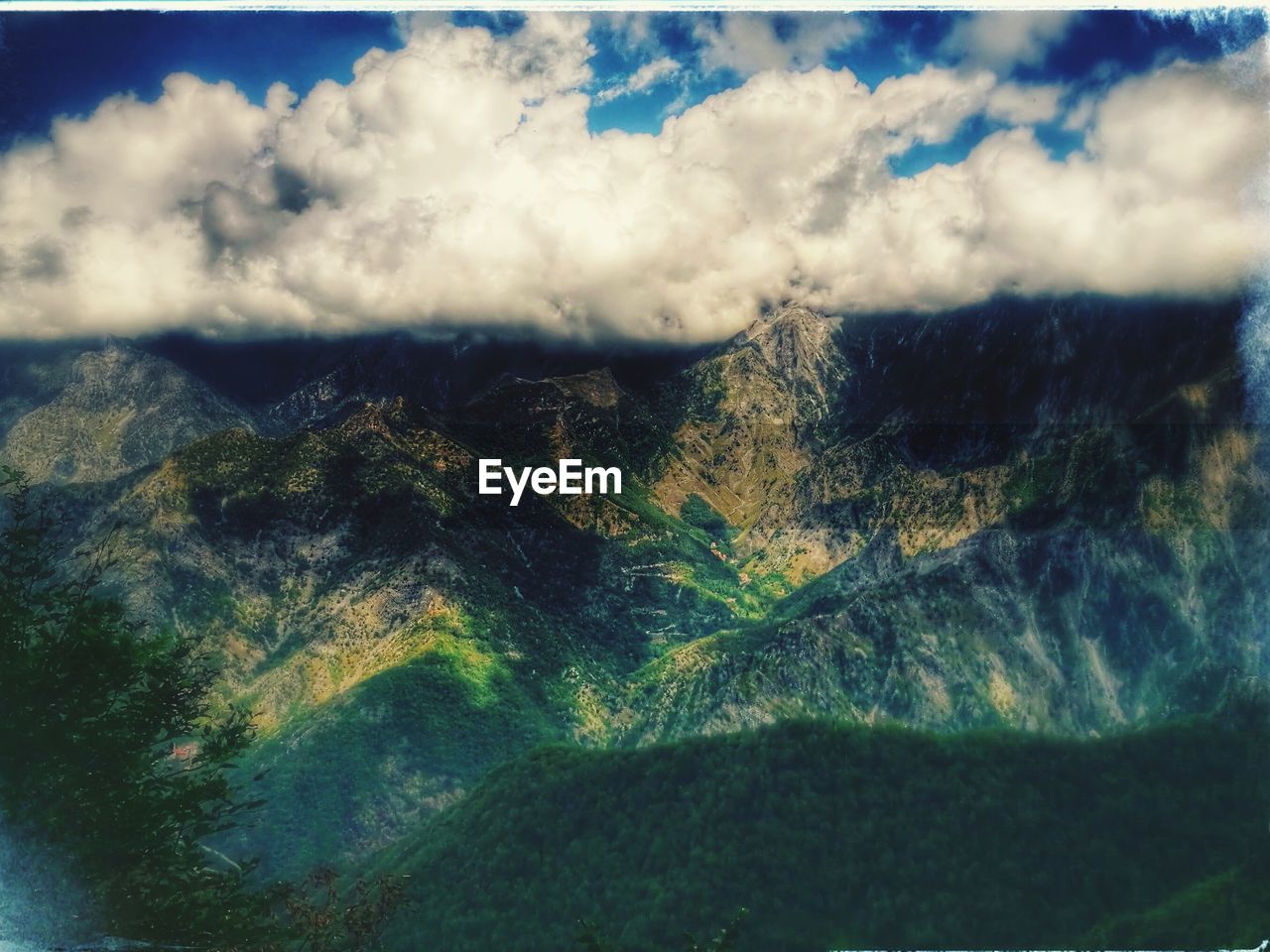 SCENIC VIEW OF MOUNTAINS AGAINST CLOUDY SKY