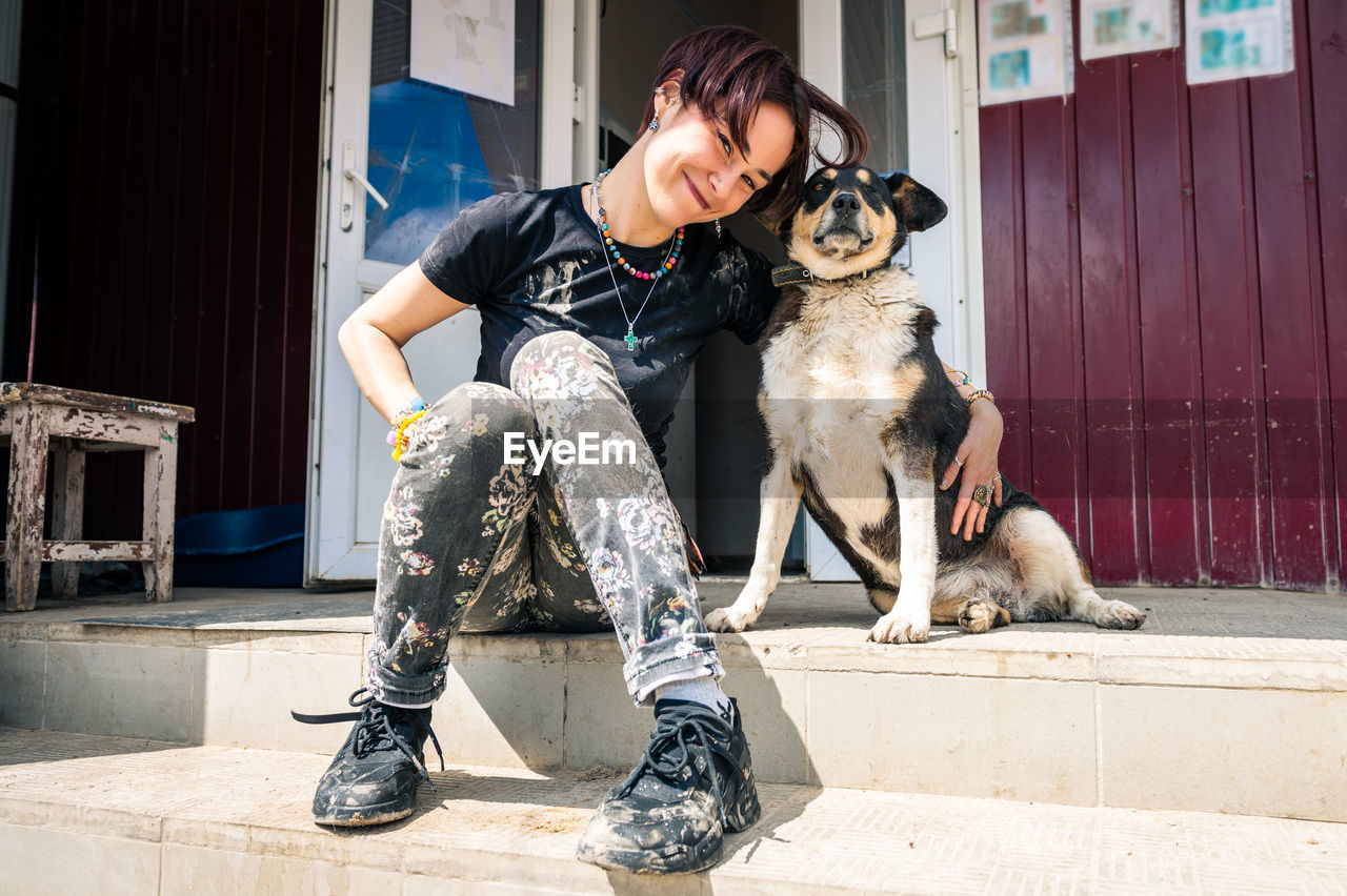 Beautiful happy woman sit and play on the lawn with her dog.  friendship concept