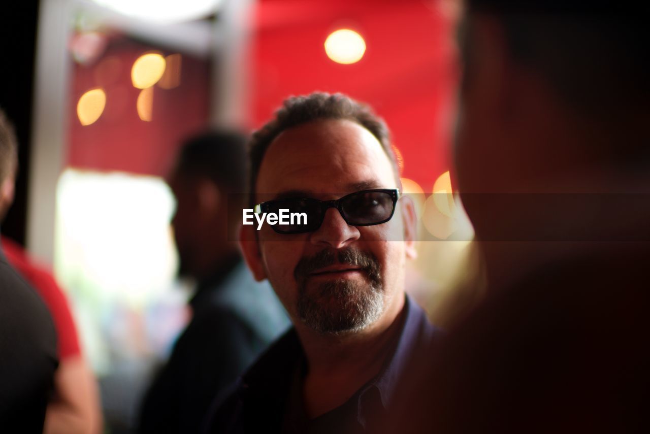 Close-up portrait of man wearing sunglasses indoors