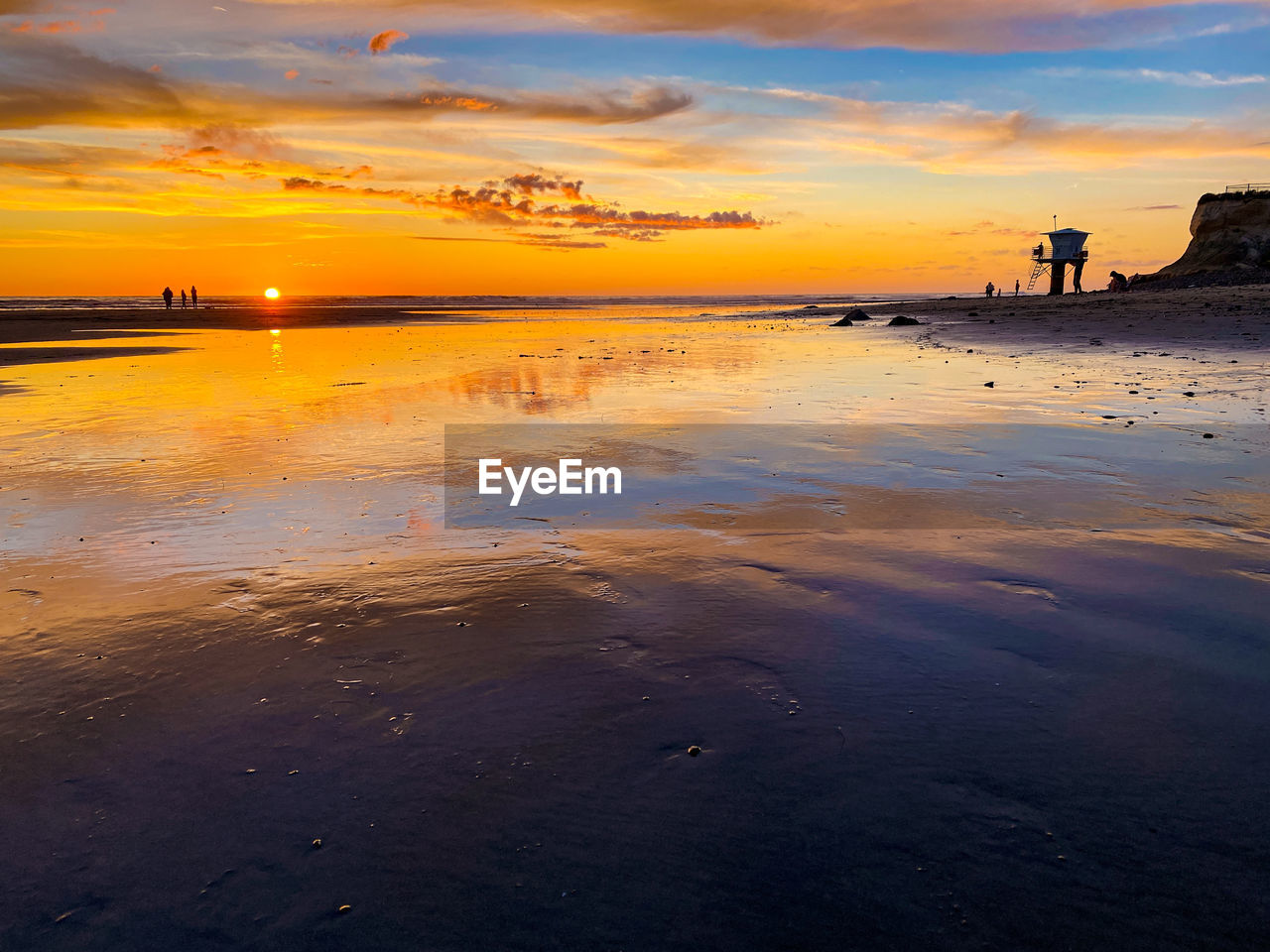 Warm sunset over reflective sand beach landscape