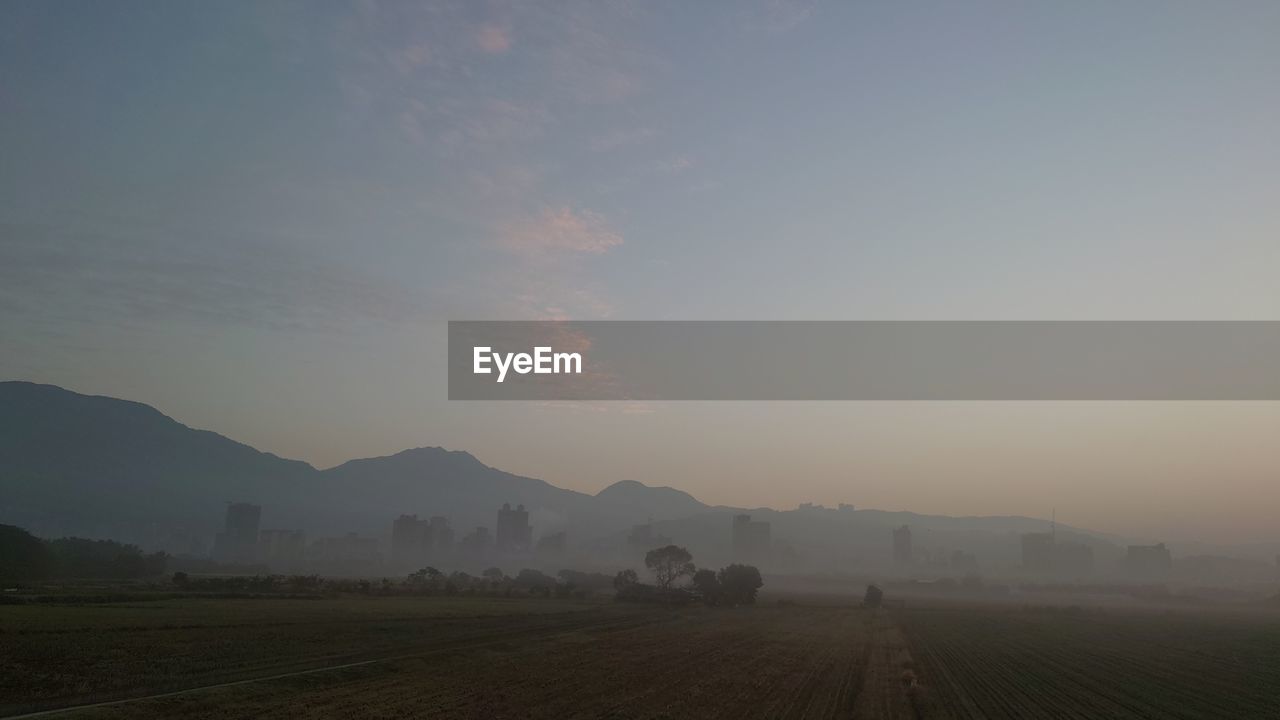 landscape, environment, sky, morning, horizon, dawn, fog, scenics - nature, nature, sunrise, land, rural scene, mountain, field, beauty in nature, agriculture, mist, tranquility, plain, farm, no people, tranquil scene, sun, plant, cloud, crop, haze, mountain range, outdoors, sunlight, twilight, idyllic, travel, rural area