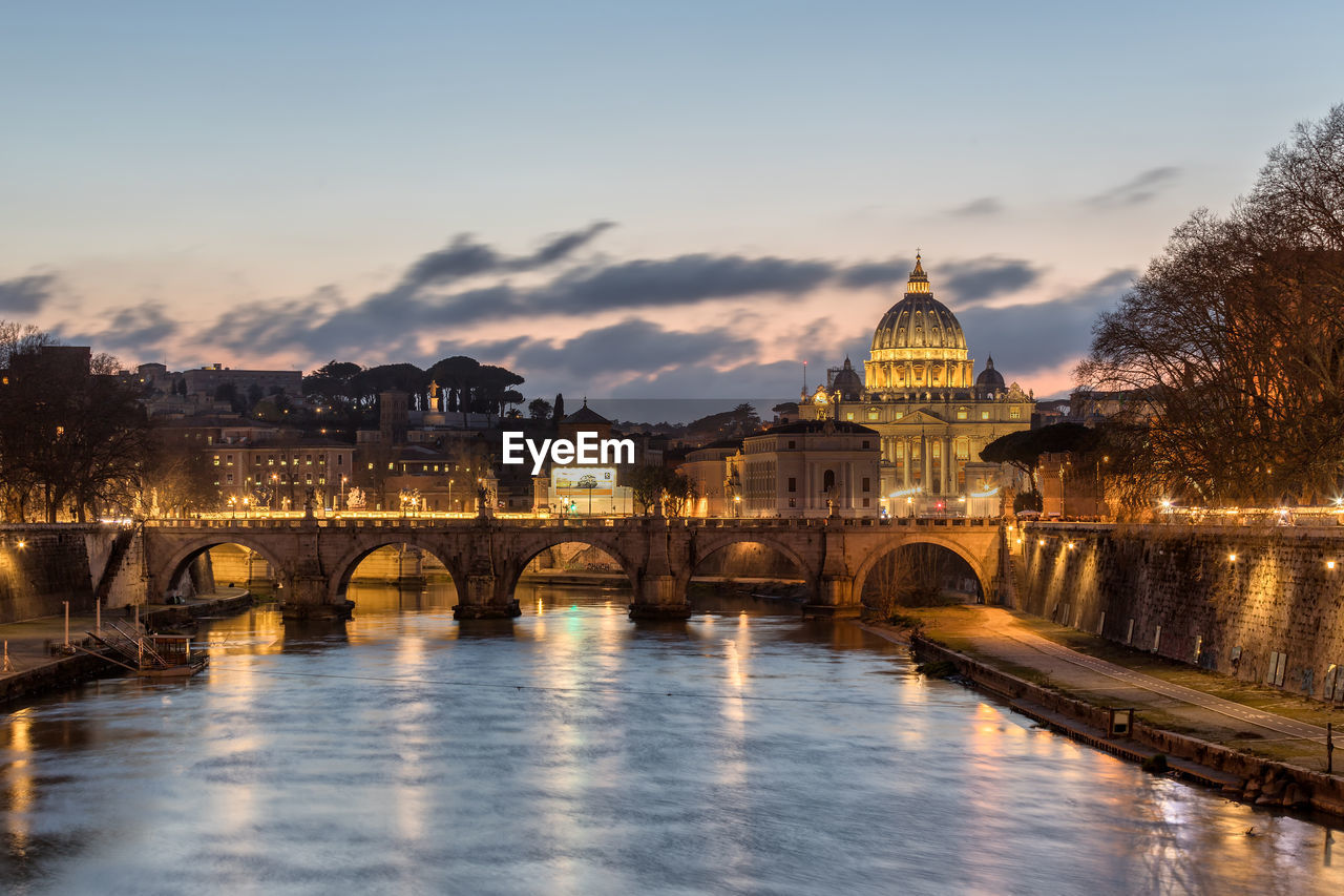 ARCH BRIDGE OVER RIVER AGAINST BUILDINGS