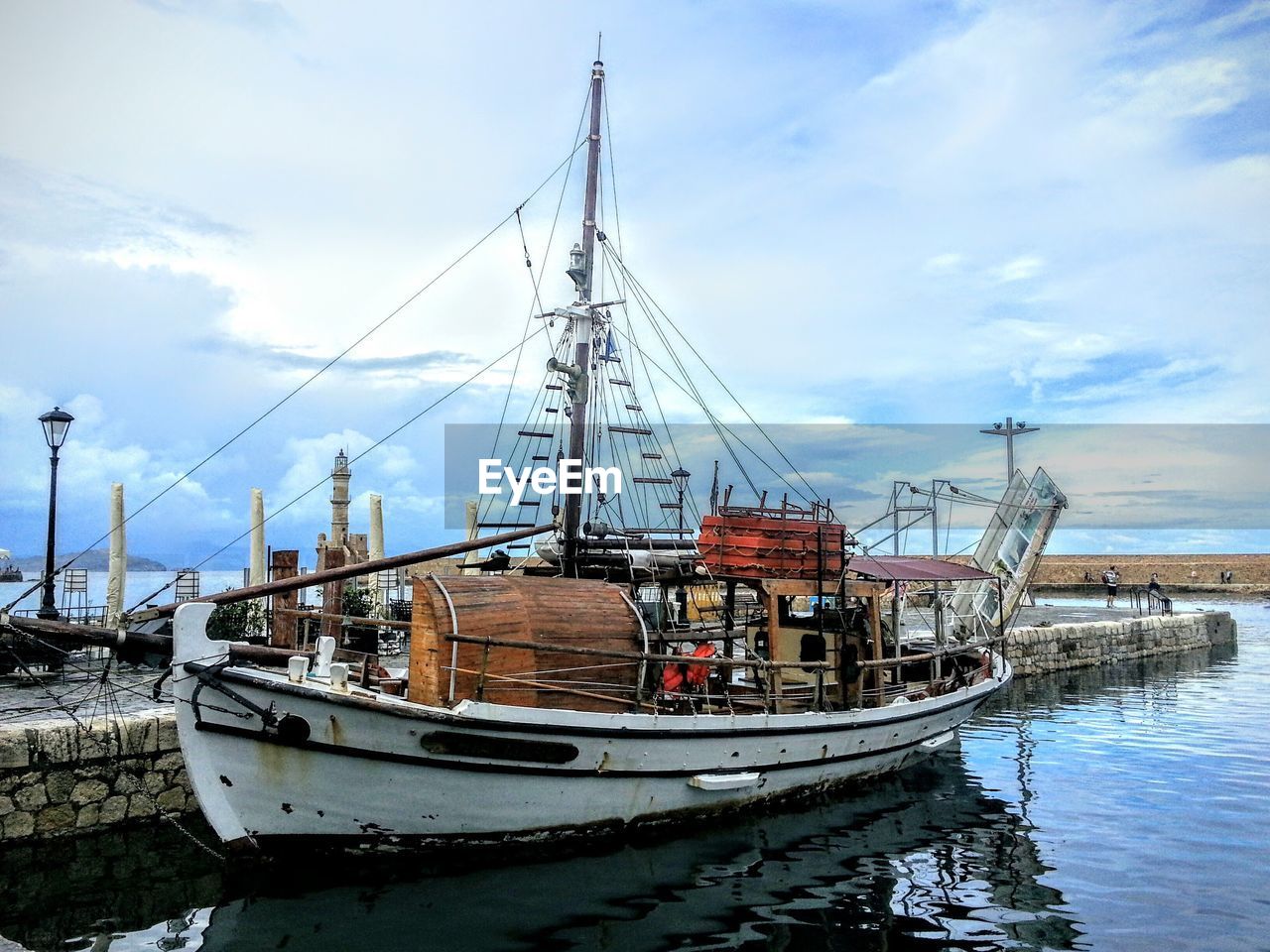 BOATS MOORED IN HARBOR AGAINST SKY