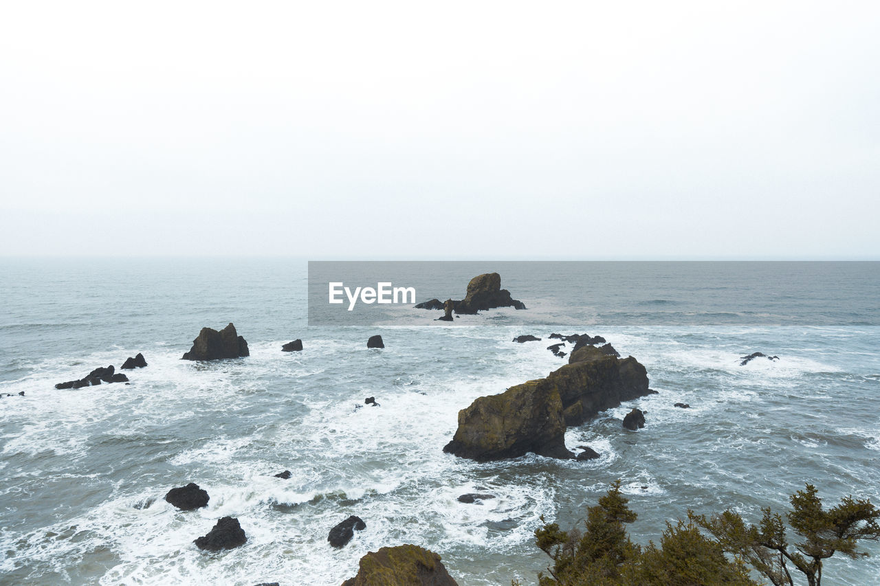 Aerial view of rock formation in sea against clear sky