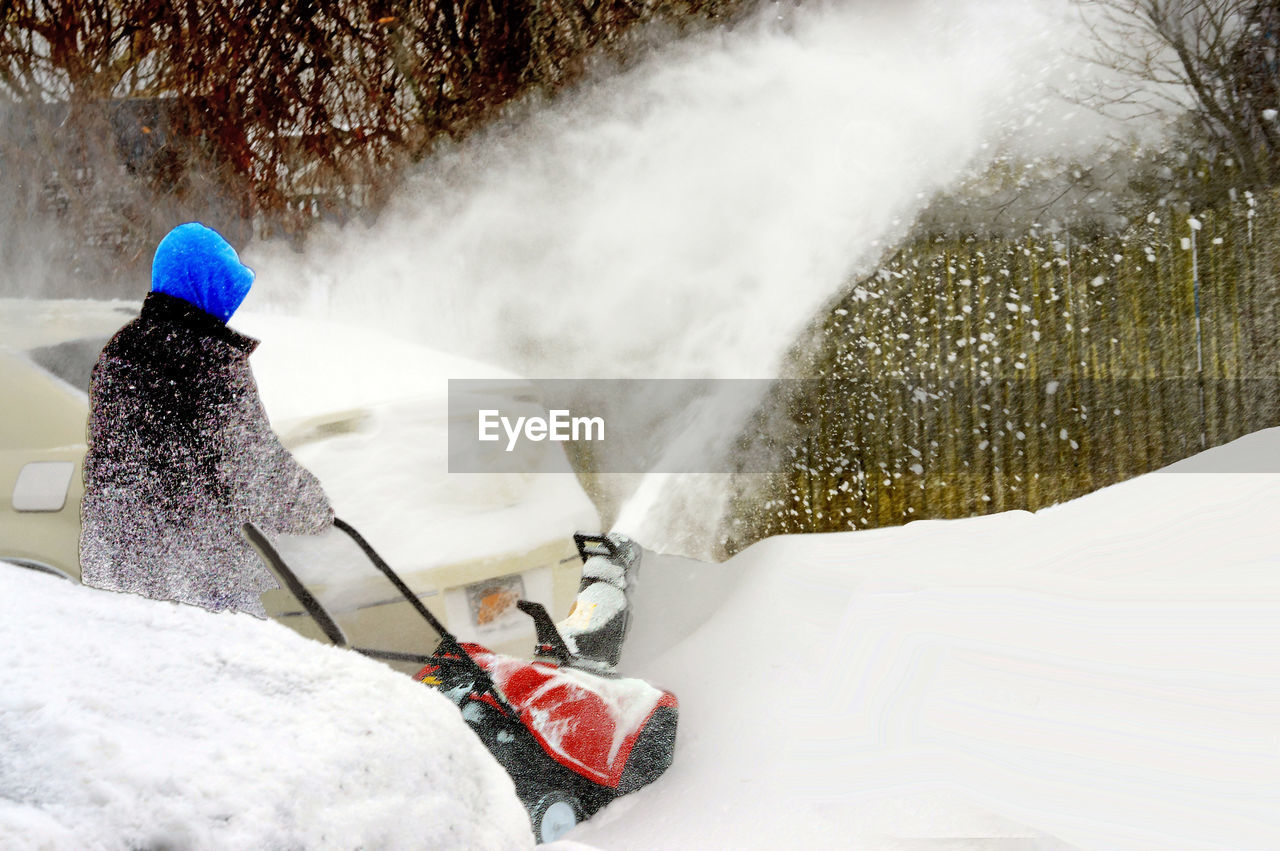 REAR VIEW OF PERSON SKIING ON SNOW