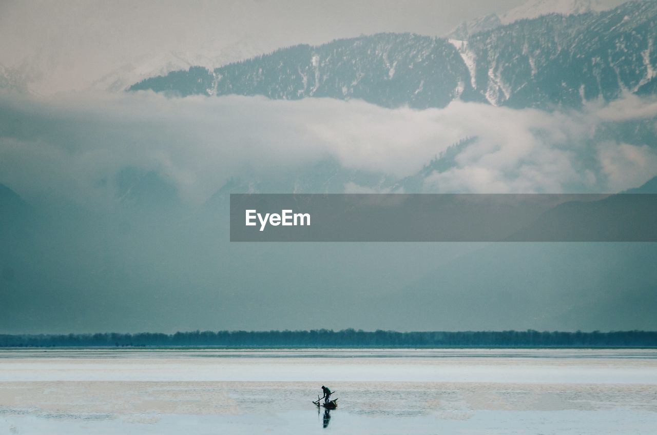 Scenic view of snowcapped mountains and boat in the lake