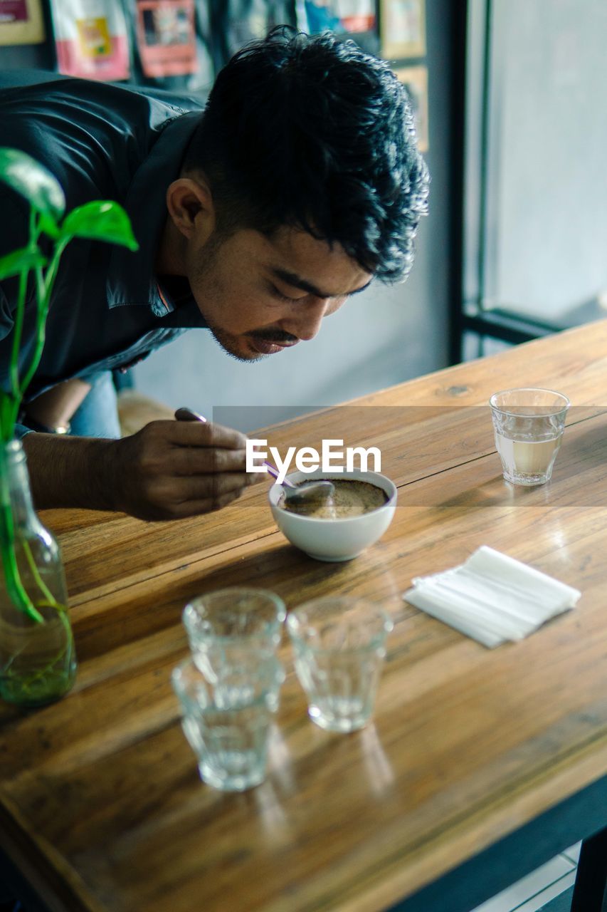 Young man preparing coffee on table