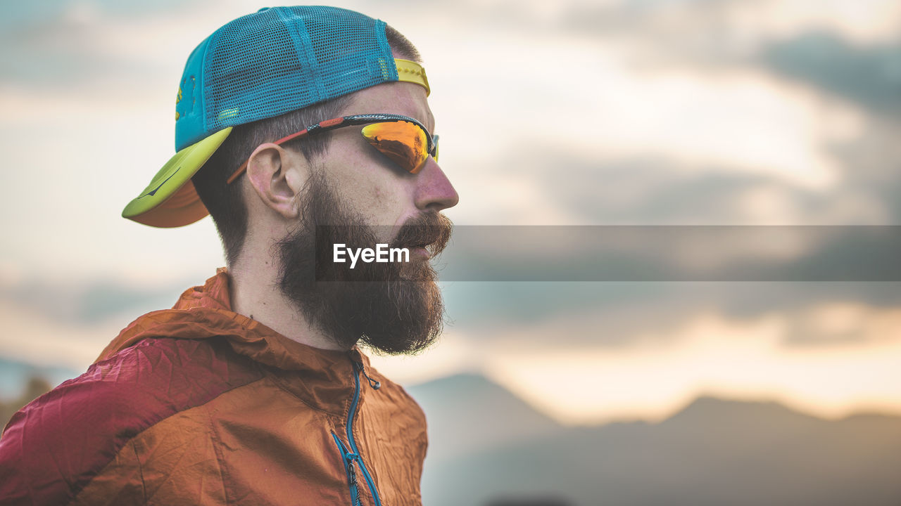 Sporty man with beard and hat in the mountains