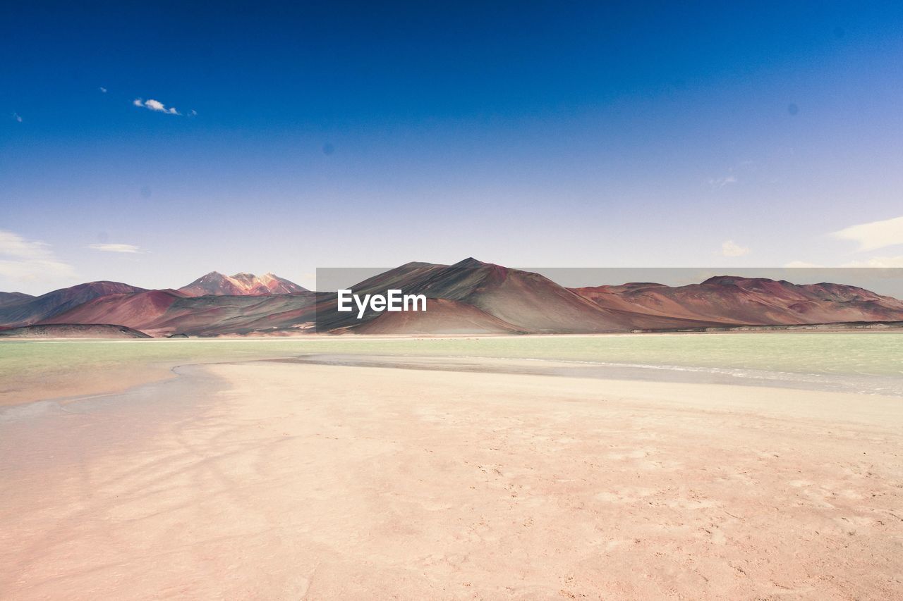 Scenic view of landscape and mountains against blue sky