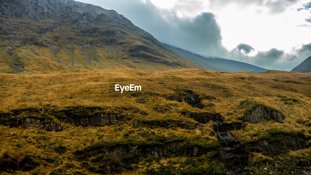 Scenic view of mountains against cloudy sky