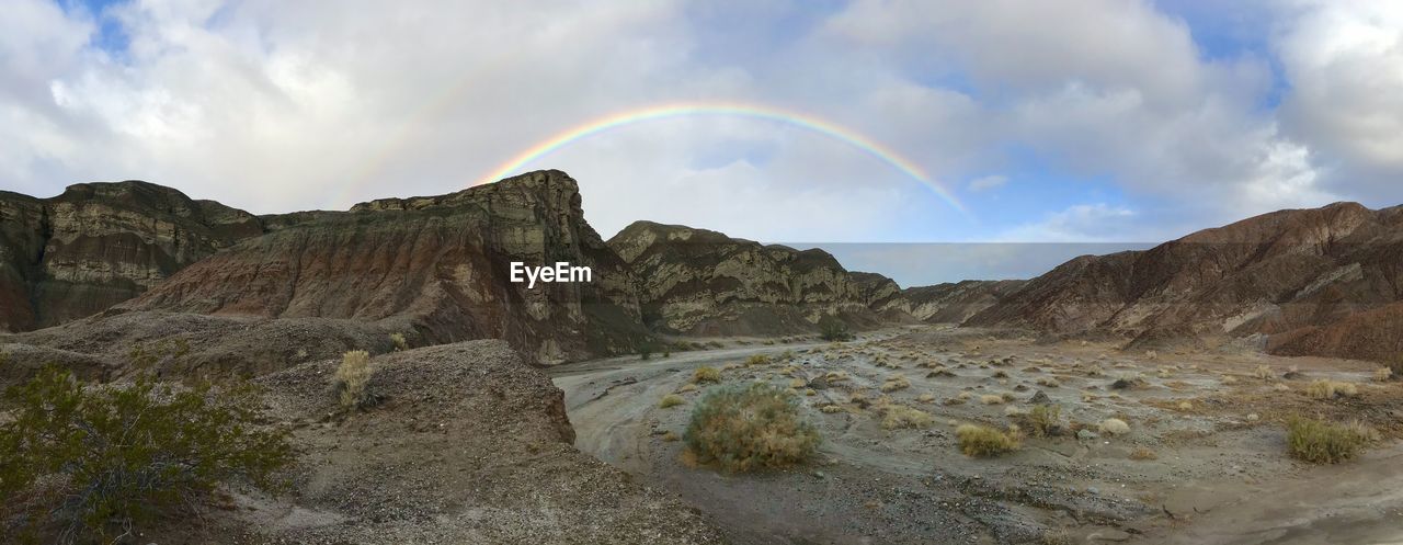 Panoramic view of rainbow over mountains against sky