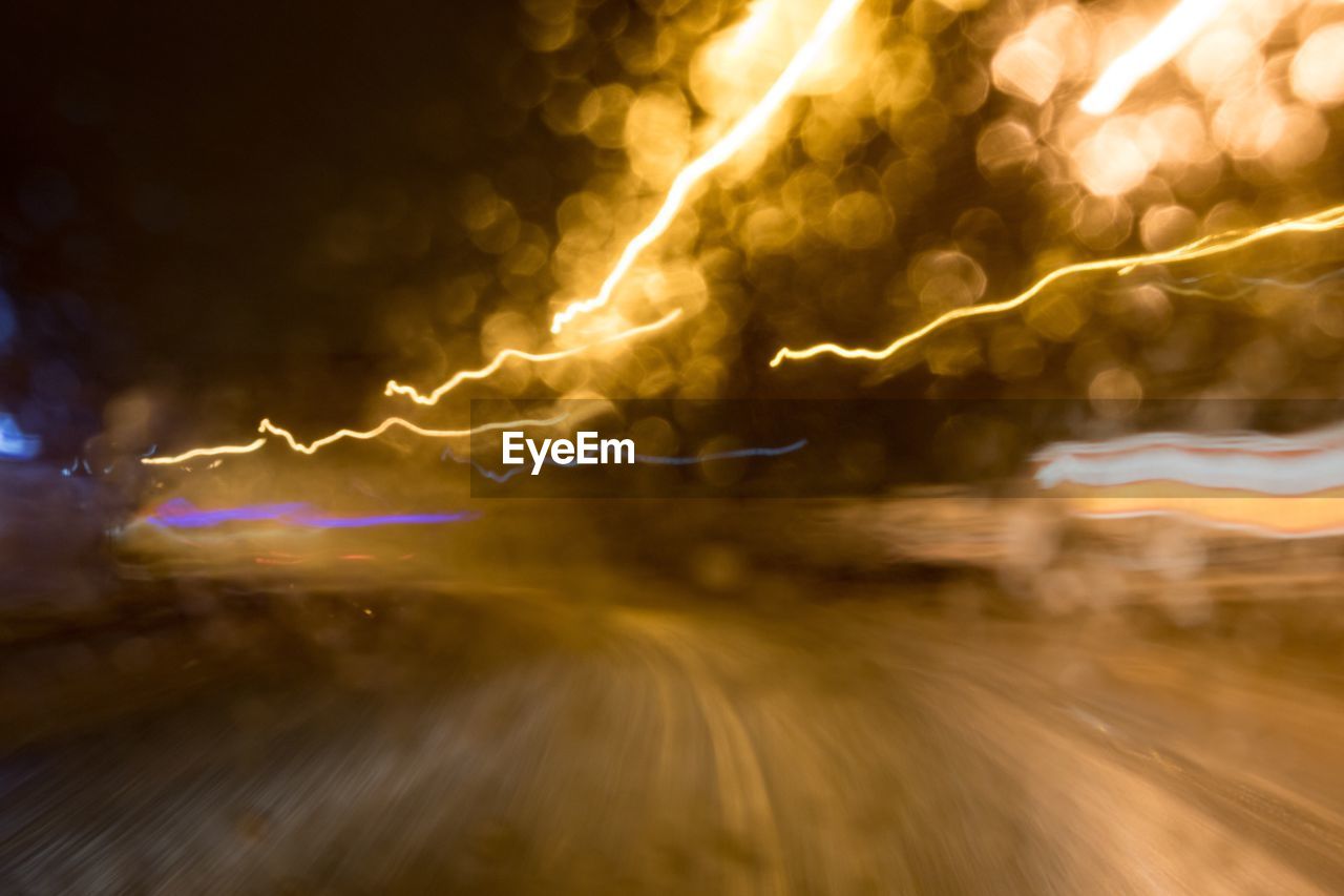 LIGHT TRAILS ON STREET AT NIGHT