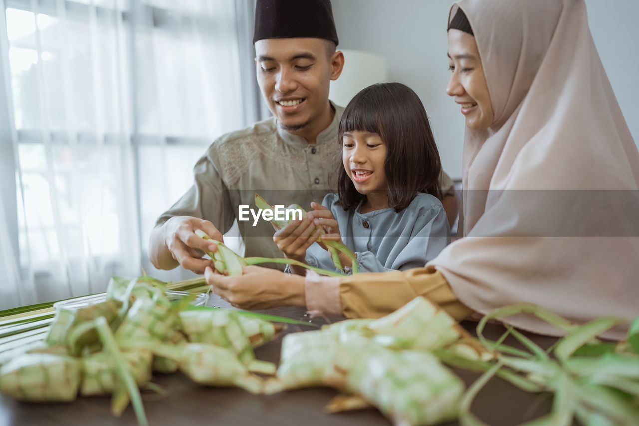 portrait of smiling friends with vegetables on table