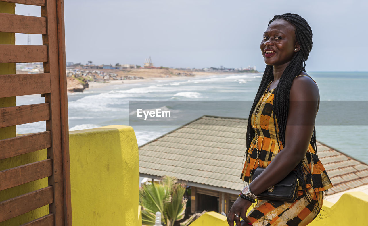 Africa woman from ghana is happy at an entrance to a seafront restaurant in accra ghana west africa.