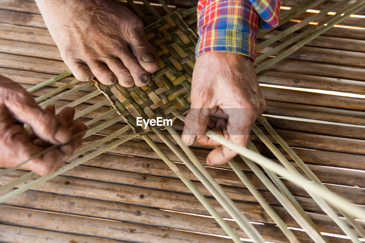 Low section of person working on wicker