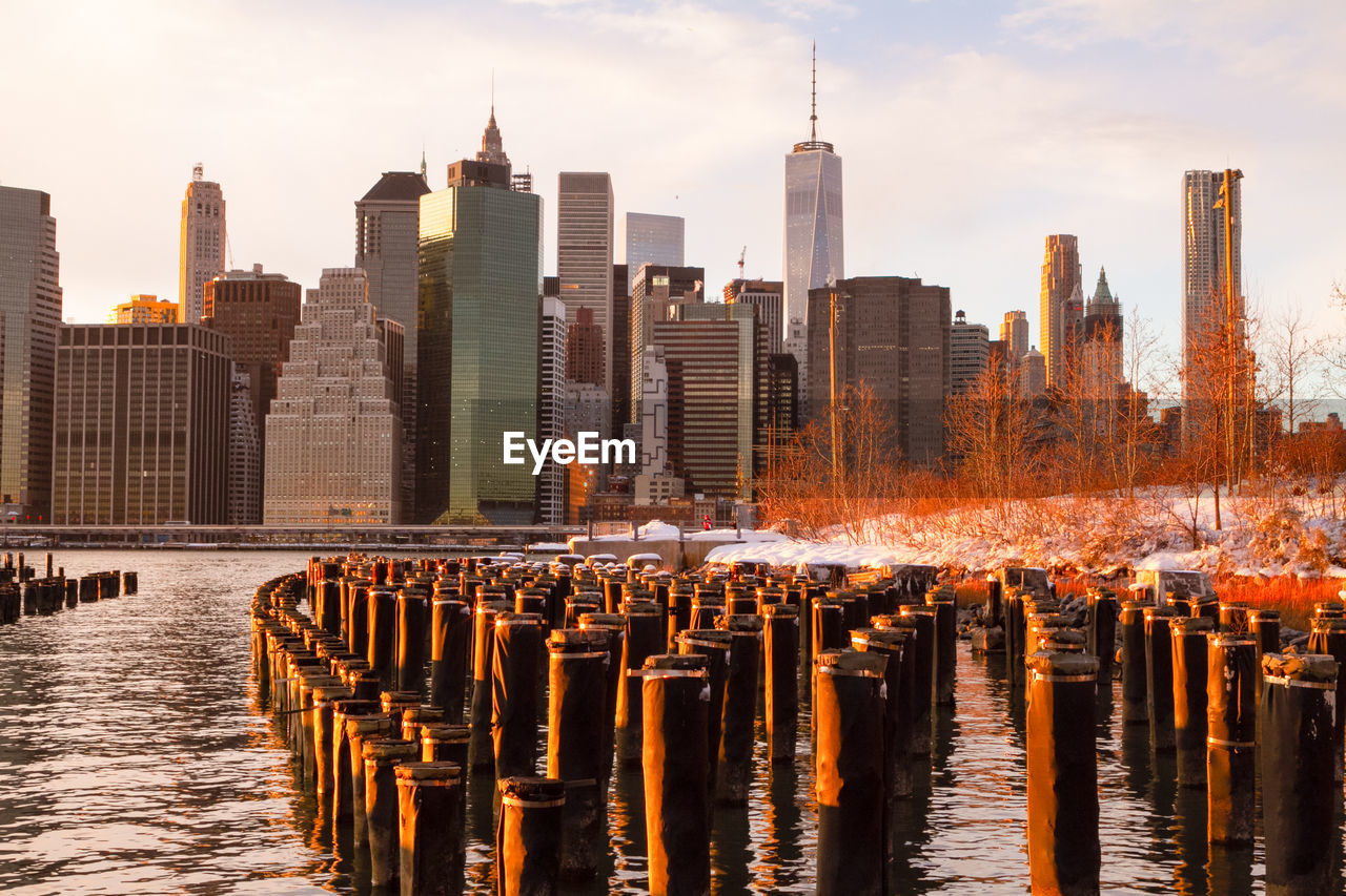 Lower manhattan at sunrise with wooden piers in the foreground as well as snow