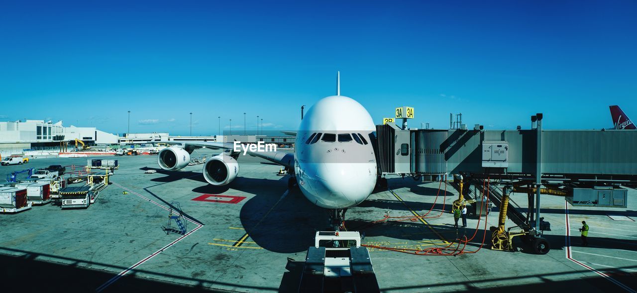 Airplane on airport runway against clear blue sky