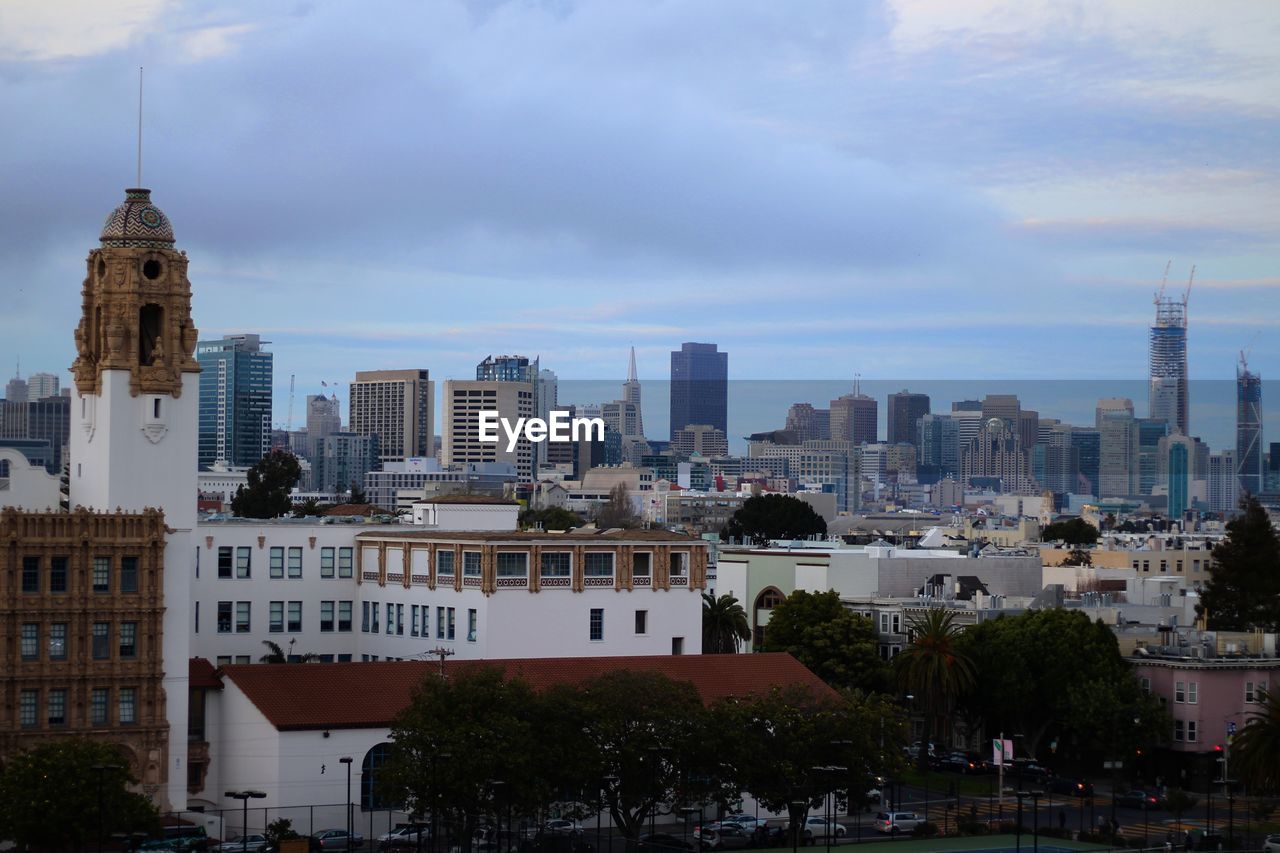 View of cityscape against cloudy sky