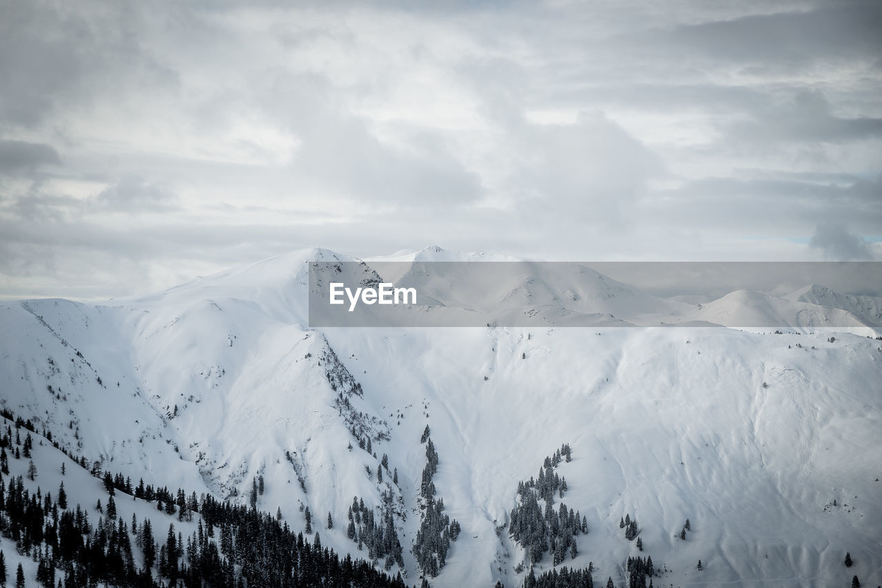 Scenic view of snow covered mountains against sky