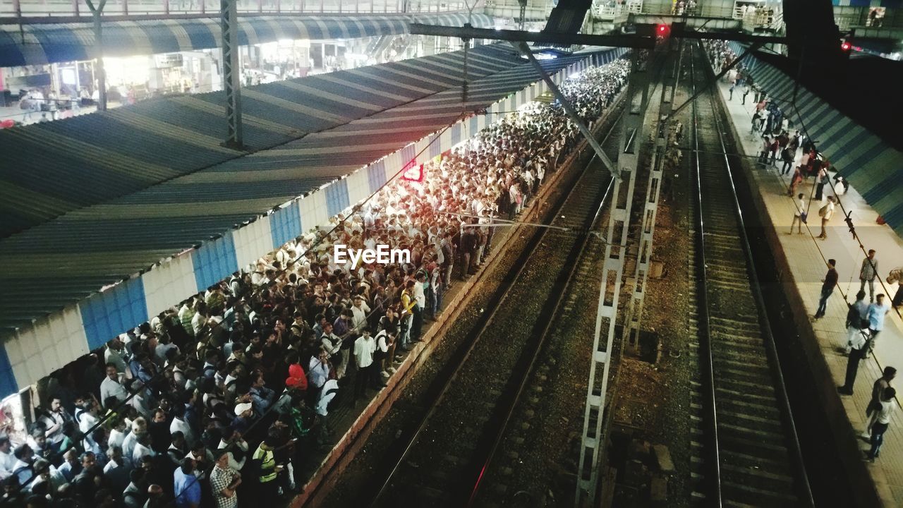 HIGH ANGLE VIEW OF PEOPLE AT SUBWAY PLATFORM