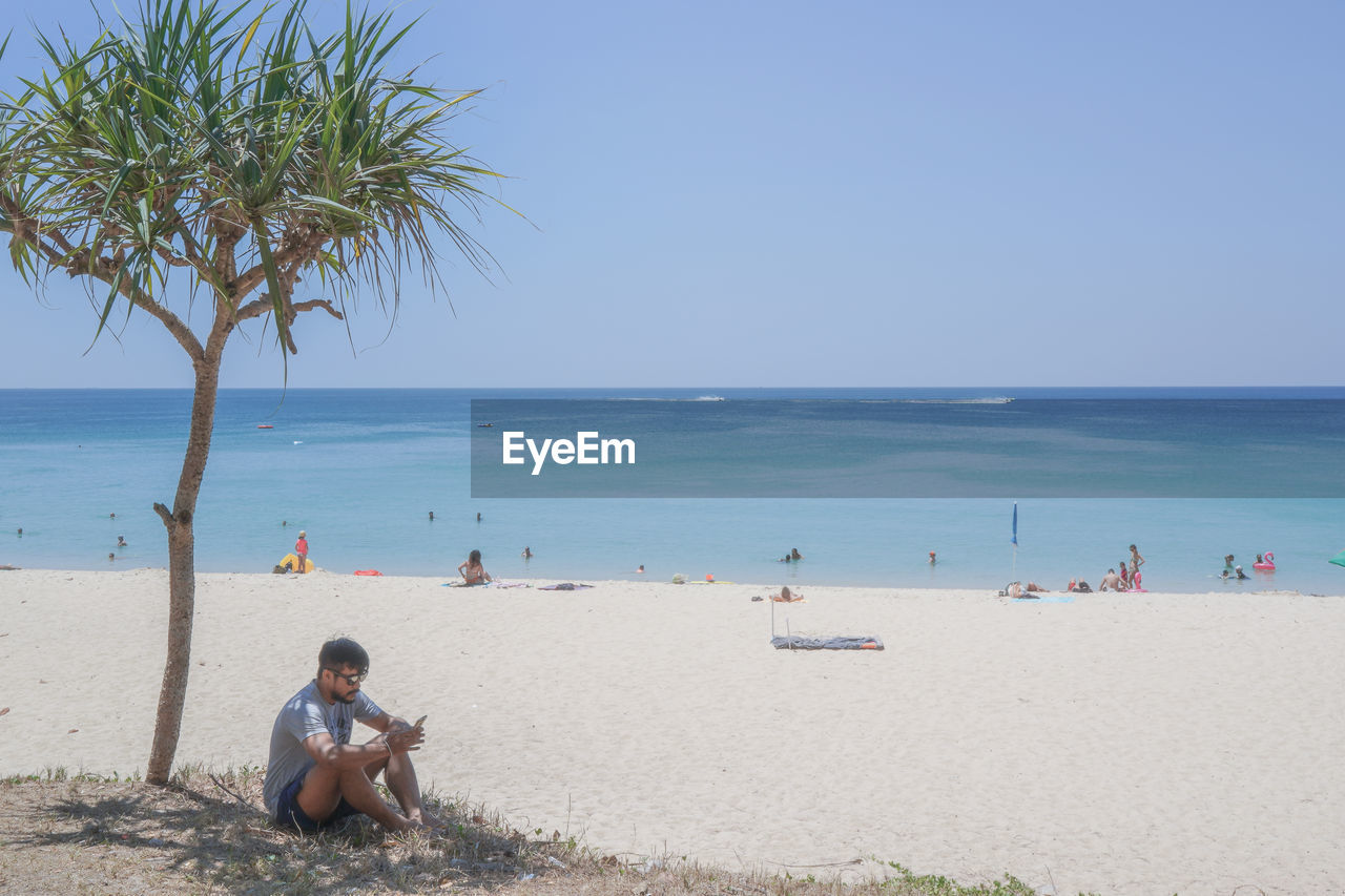 PEOPLE SITTING ON BEACH