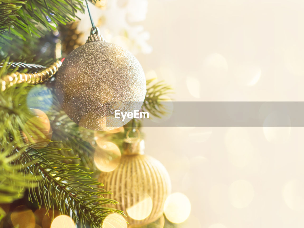 New year christmas tree background with golden ornaments and holiday lights bokeh