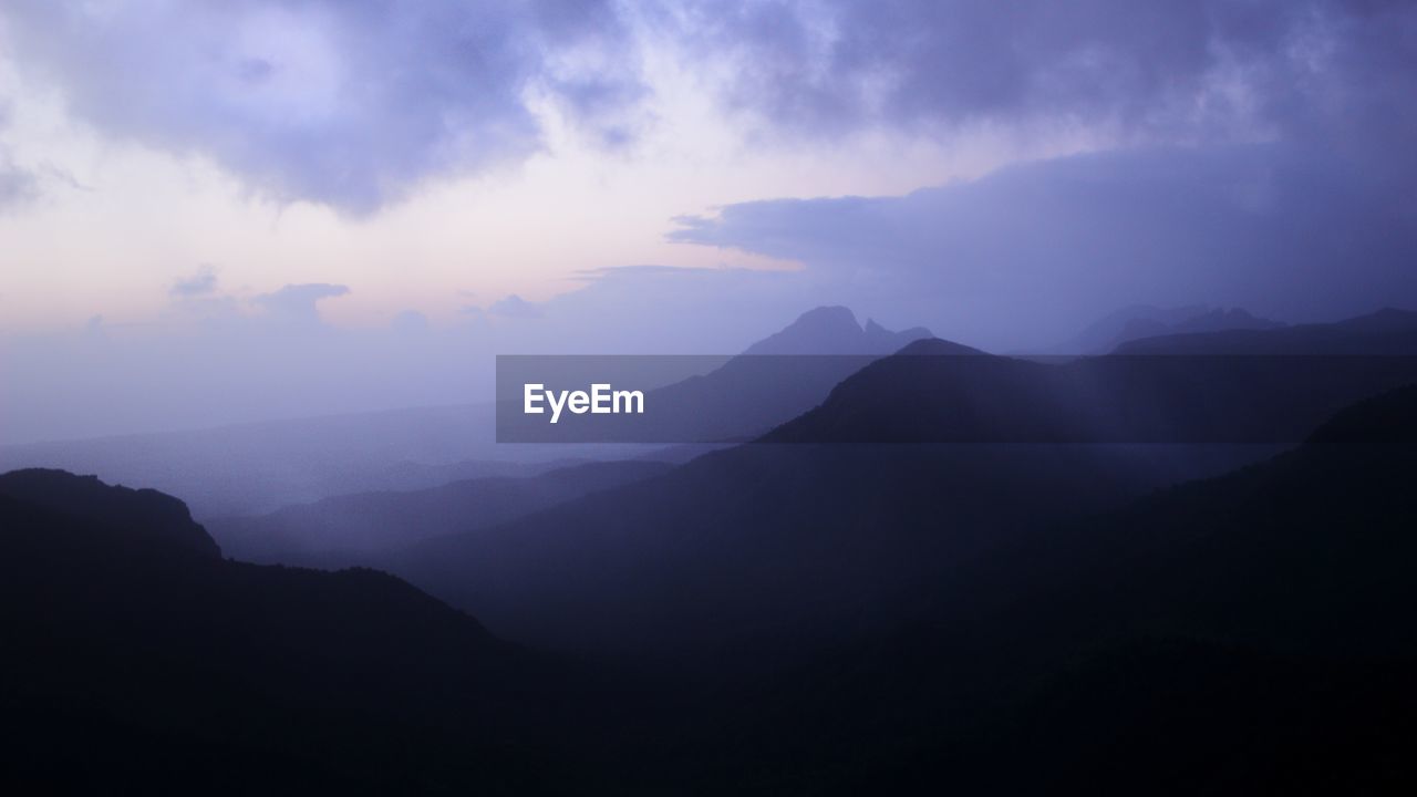 Scenic view of silhouette mountains against sky at dusk