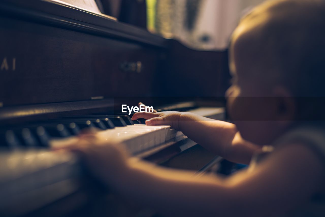 Close-up of baby girl playing piano at home