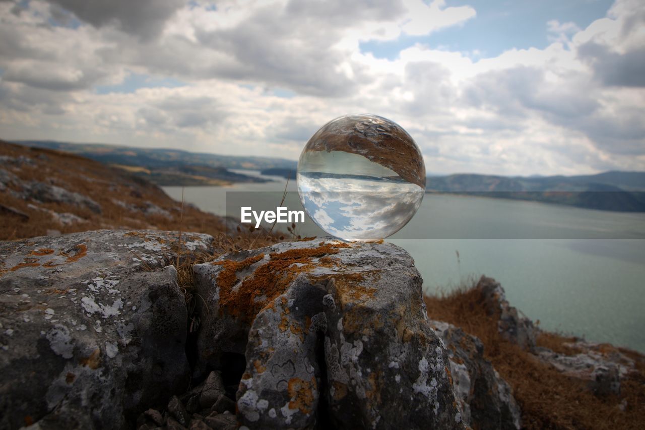 Scenic view of rock in sea against sky