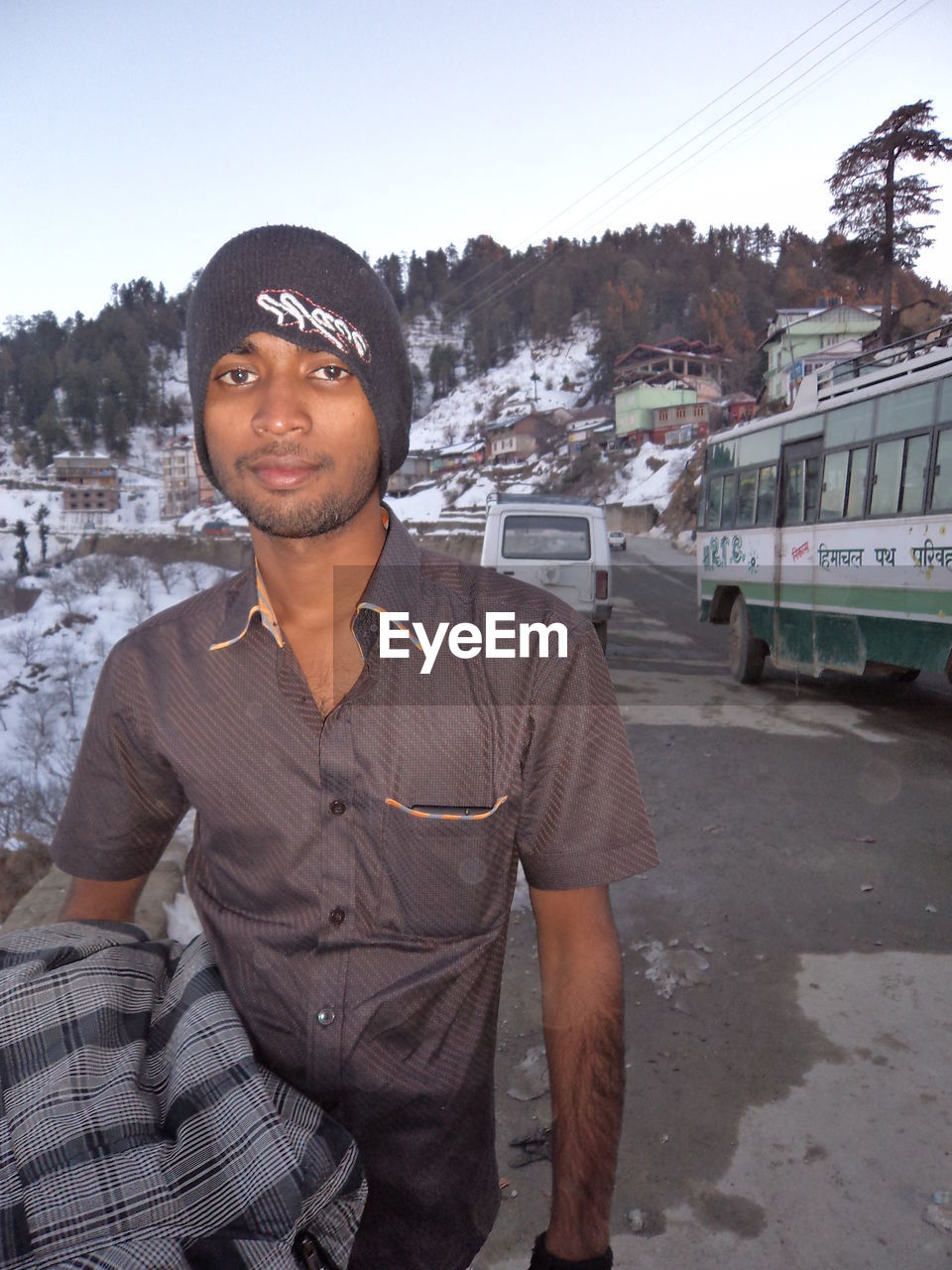 Portrait of smiling man on road against snow covered mountain