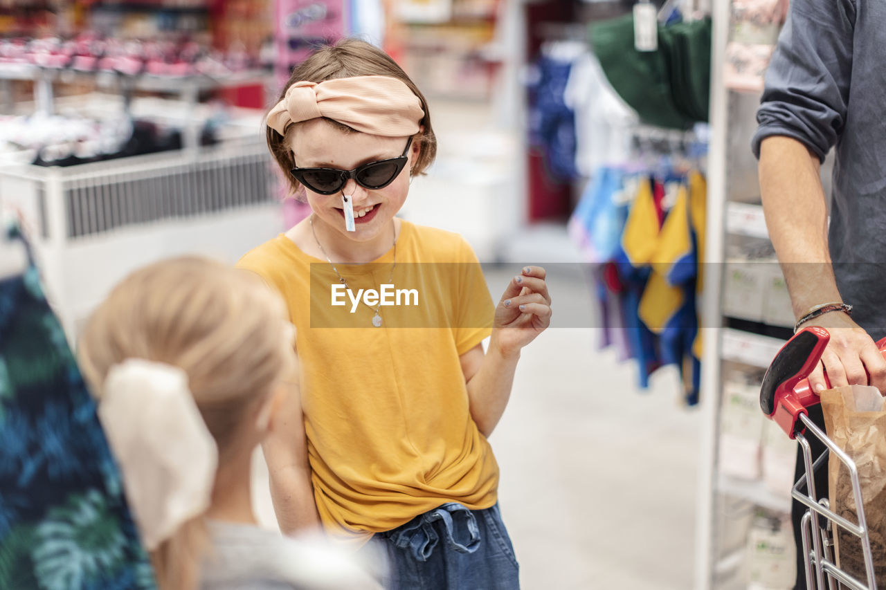 Smiling girl trying sunglasses in shop