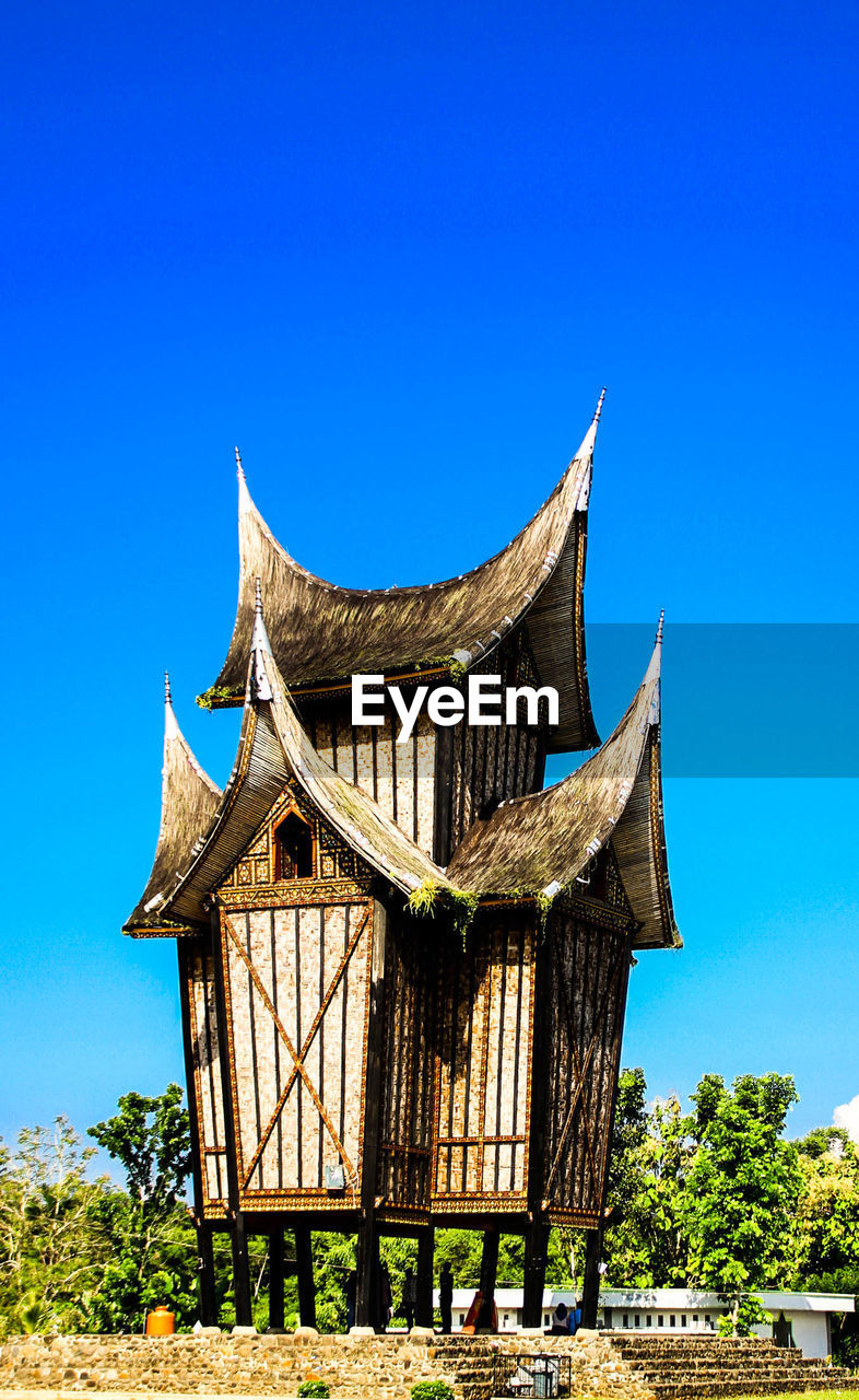 Low angle view of barn against clear blue sky