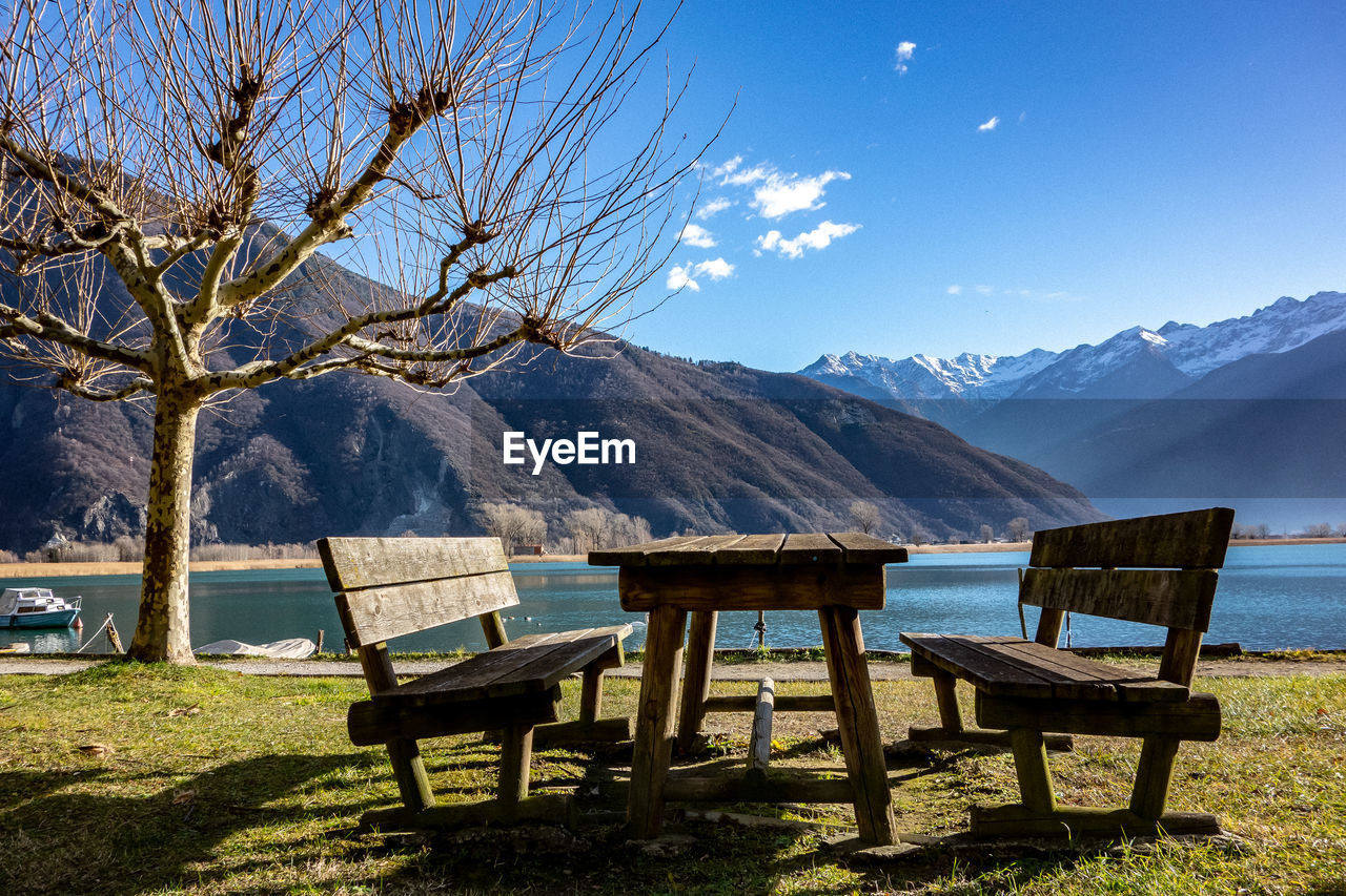 CHAIRS AND TABLE AGAINST SNOWCAPPED MOUNTAINS