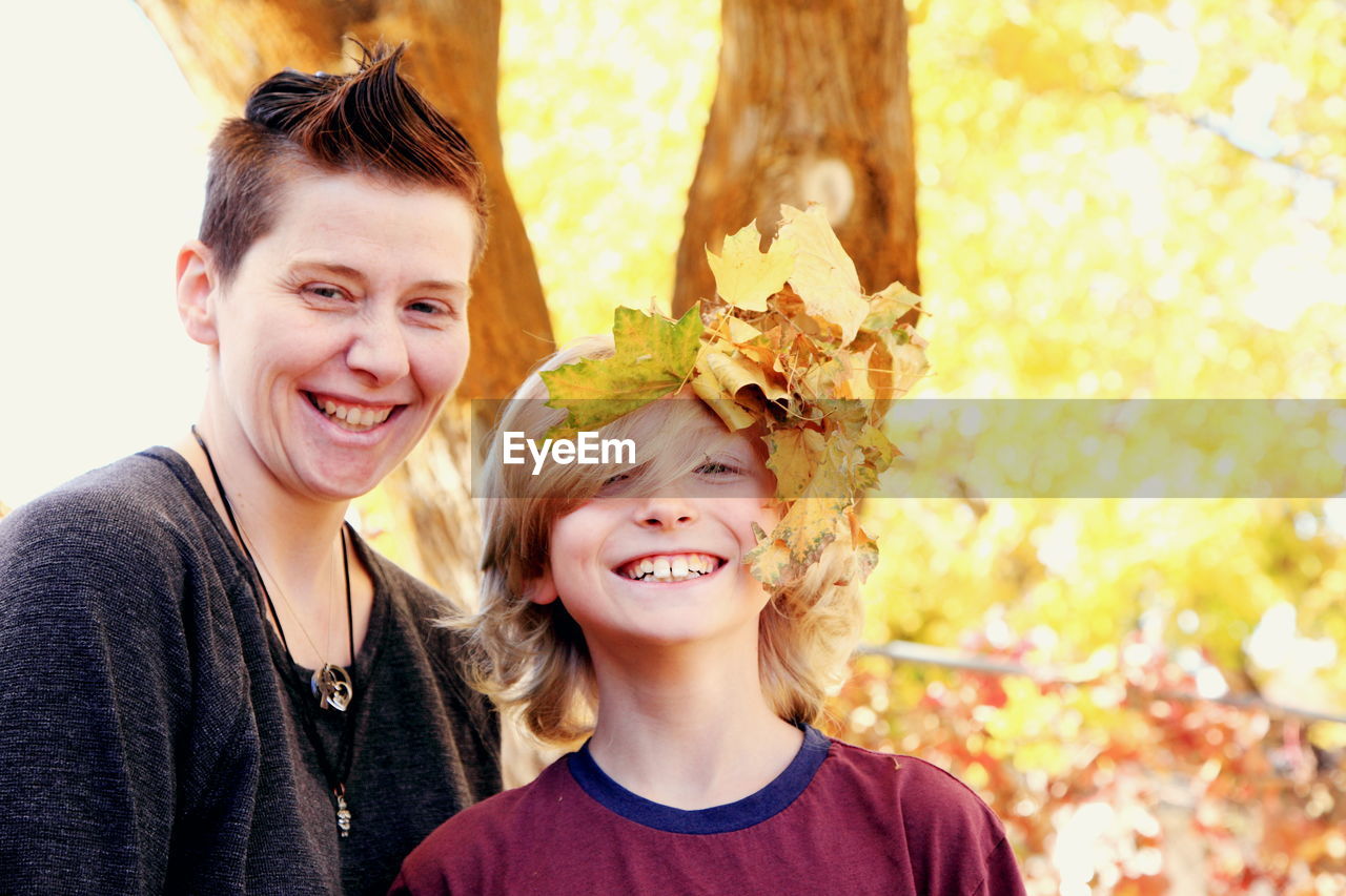 Portrait of happy mother and son in park during autumn