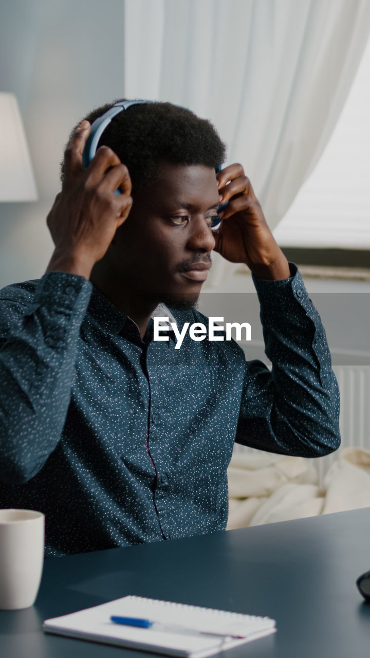 Man wearing headphones while sitting at home