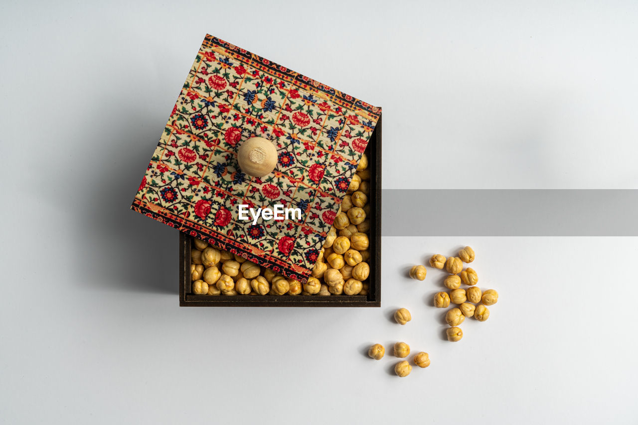 High angle view of chickpeas in a traditional wooden box on white background