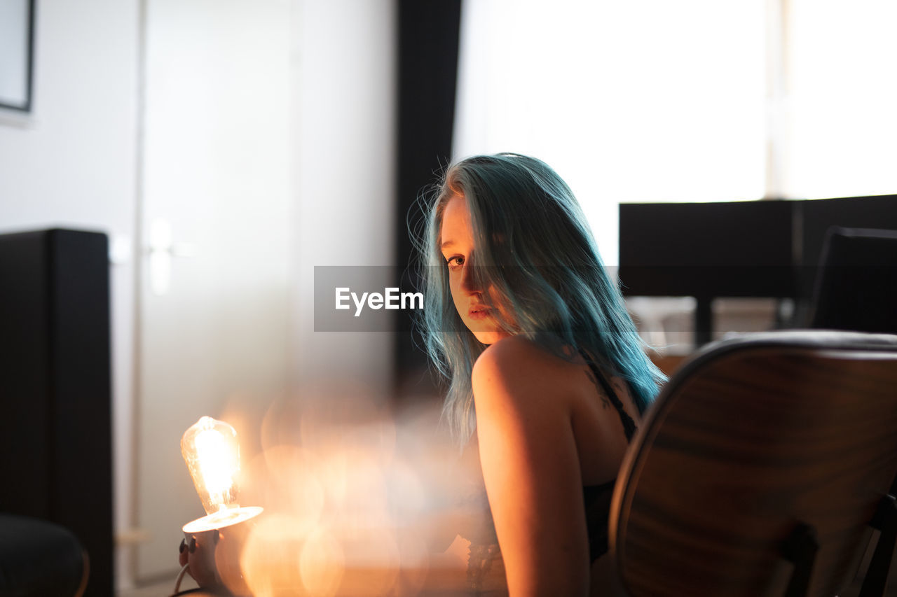 Woman looking away while sitting on table