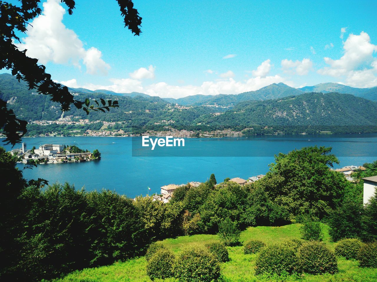 View of island amidst lake with mountains in foreground