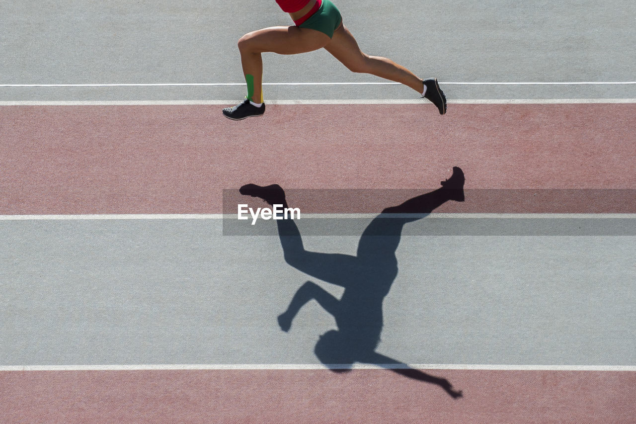 Low section of woman running on track