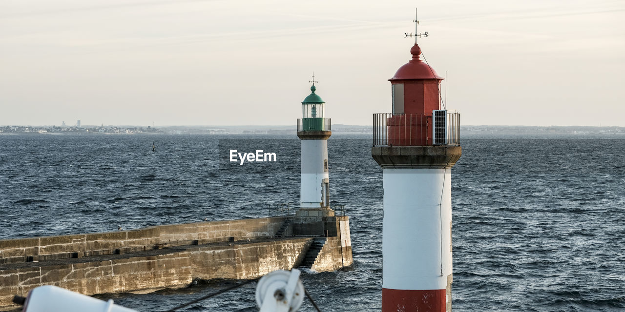 LIGHTHOUSE BY SEA AGAINST SKY AND BUILDING