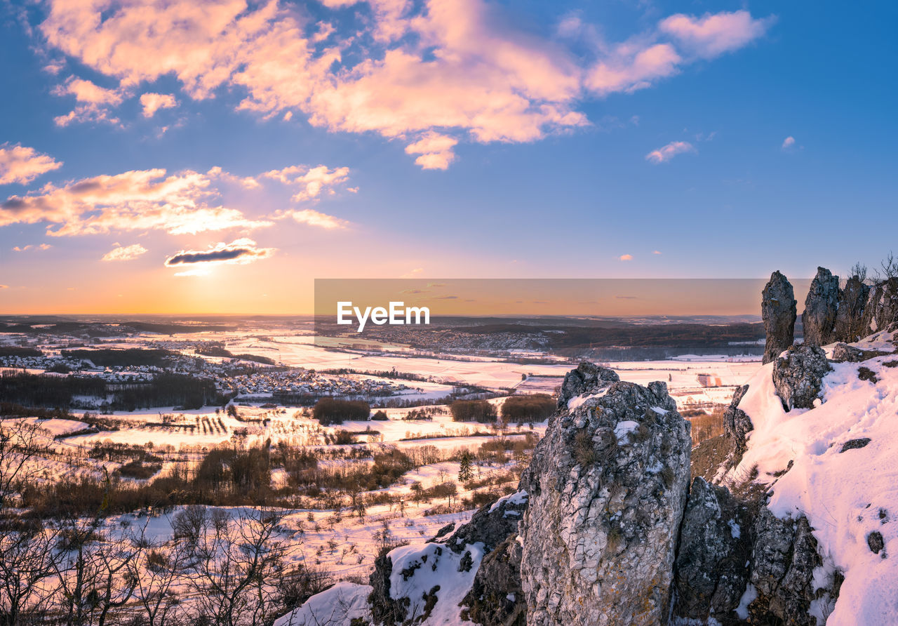 Panoramic view of winter landscape against sky during sunset