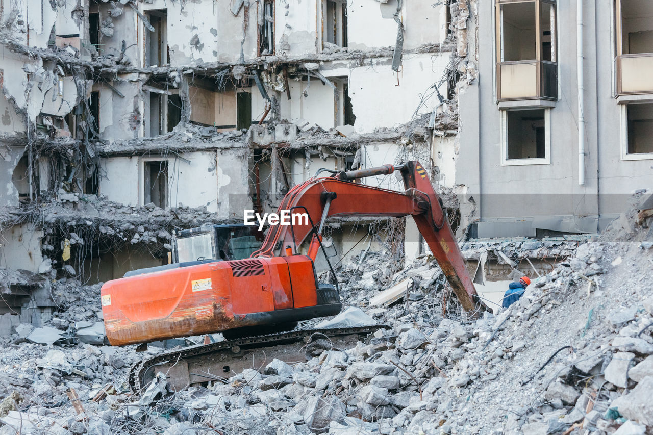 Cleaning of construction debris with a bucket of an excavator. building demolition backhoe