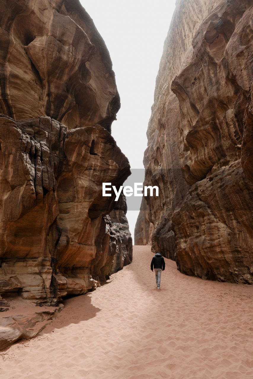 The desert walker. man walking through a canyon in the desert of wadi rum. 