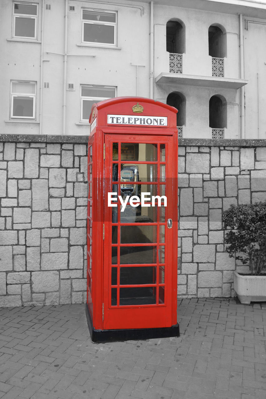 RED TELEPHONE BOOTH ON BUILDING