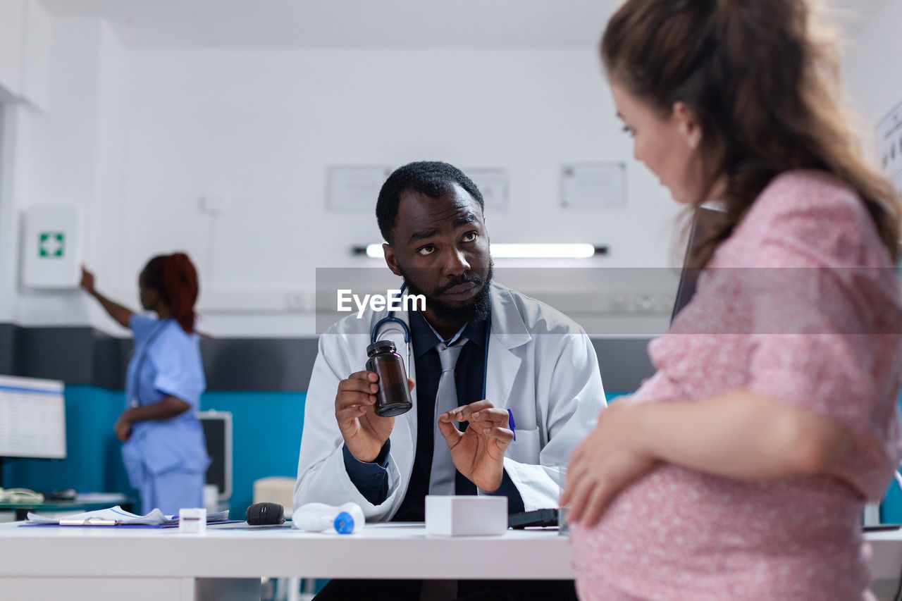 Side view of doctor examining patient at clinic