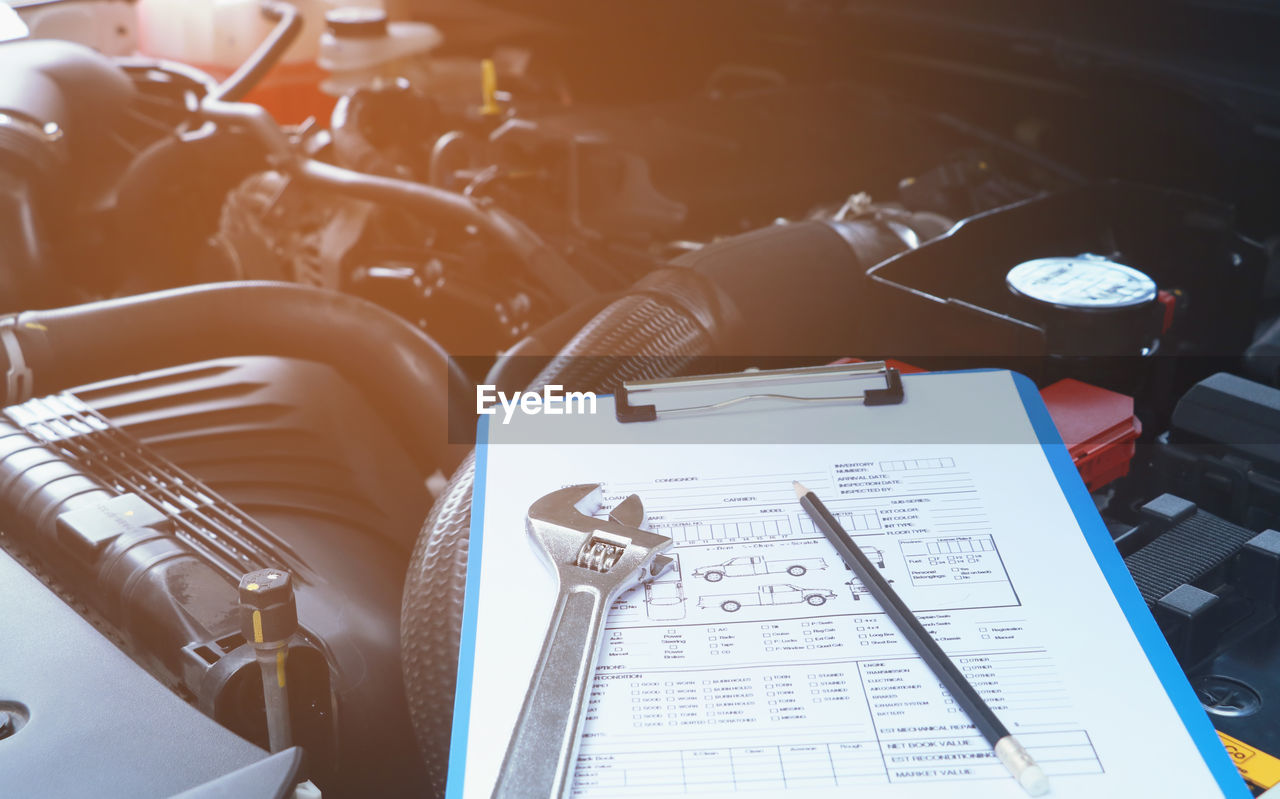 High angle view of clipboard on car engine in garage