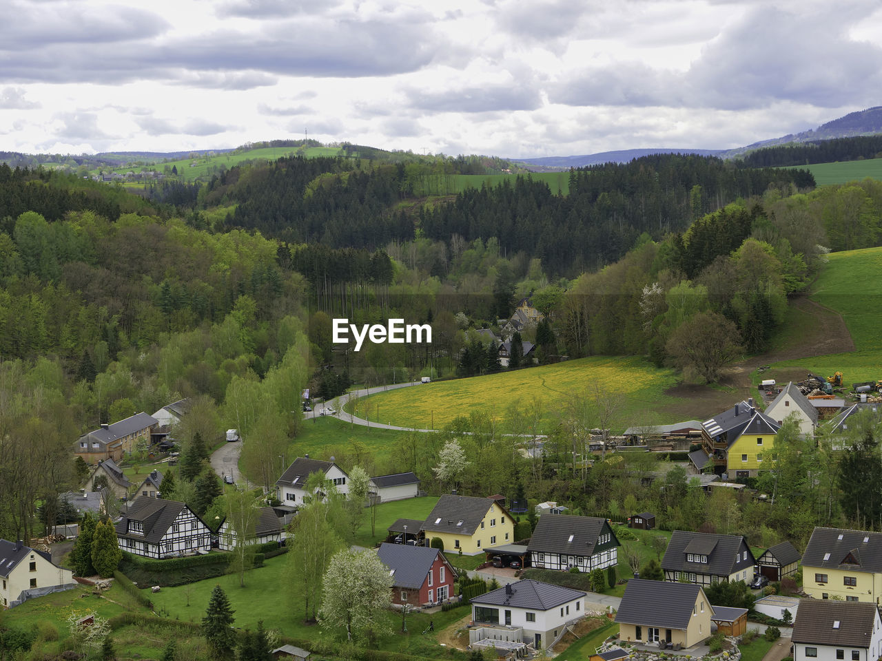 HIGH ANGLE VIEW OF TOWNSCAPE AGAINST TREES AND HOUSES