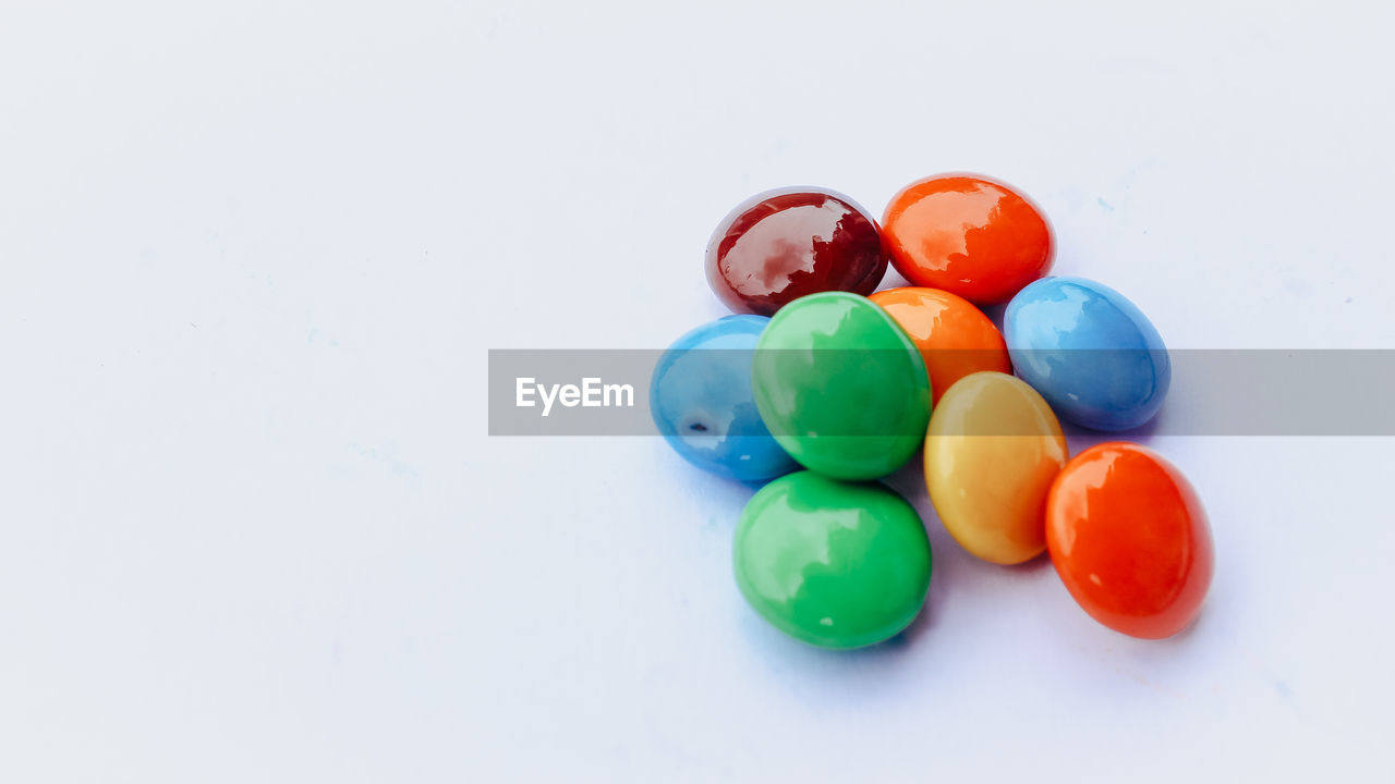 High angle view of multi colored candies on white background